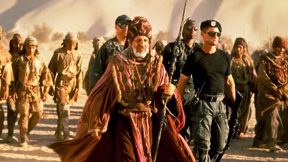 Kasuf (Erick Avari) leads Jack O'Neil (Kurt Russell) and soldiers through the desert