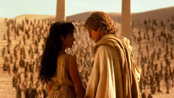 Sha'uri (Mili Avital) and Daniel Jackson (James Spader) stand together before rows of people