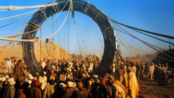 A crowd gathers around the Stargate in the desert