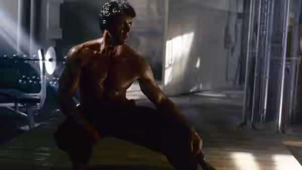 Ray Quick (Sylvester Stallone), shirtless, sits on the floor in a dim industrial room