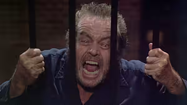 Will Randall (Jack Nicholson) grips the bars and shouts