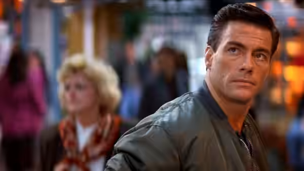 Max Walker (Jean-Claude Van Damme) looks over his shoulder in a crowded public place