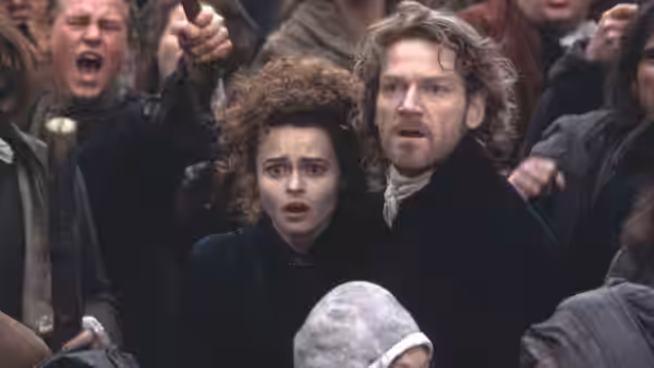Elizabeth Frankenstein and Henry Clerval stare in alarm amid an agitated crowd