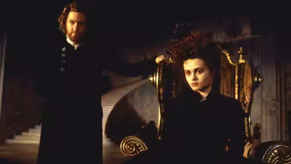 Victor Frankenstein stands beside Elizabeth seated on an ornate chair