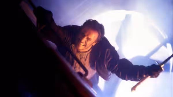 Connor MacLeod (Christopher Lambert) reaches forward with a sword amid a bright burst of light