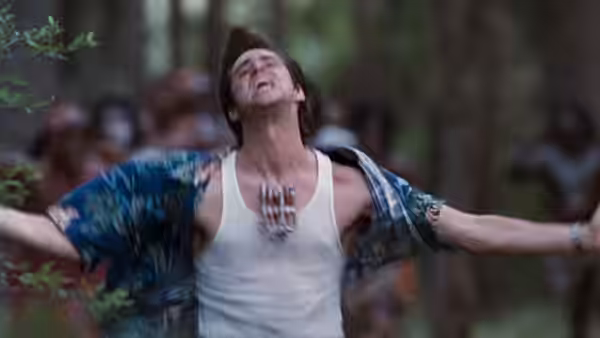 Ace Ventura (Jim Carrey) throws his arms wide before a gathered crowd