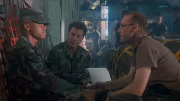 A doctor speaks with soldiers inside a crowded military medical facility