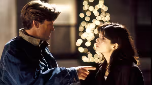 Jack (Bill Pullman) points toward Lucy (Sandra Bullock) beneath glowing Christmas lights