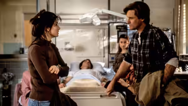 Lucy (Sandra Bullock) and Jack (Bill Pullman) stand beside Peter's hospital bed