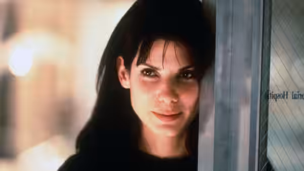 Lucy (Sandra Bullock) peeks around a doorway