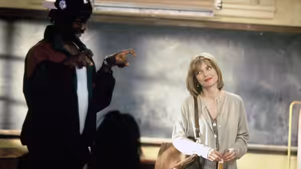 Louanne Johnson (Michelle Pfeiffer) watches a student gesture beside the classroom chalkboard