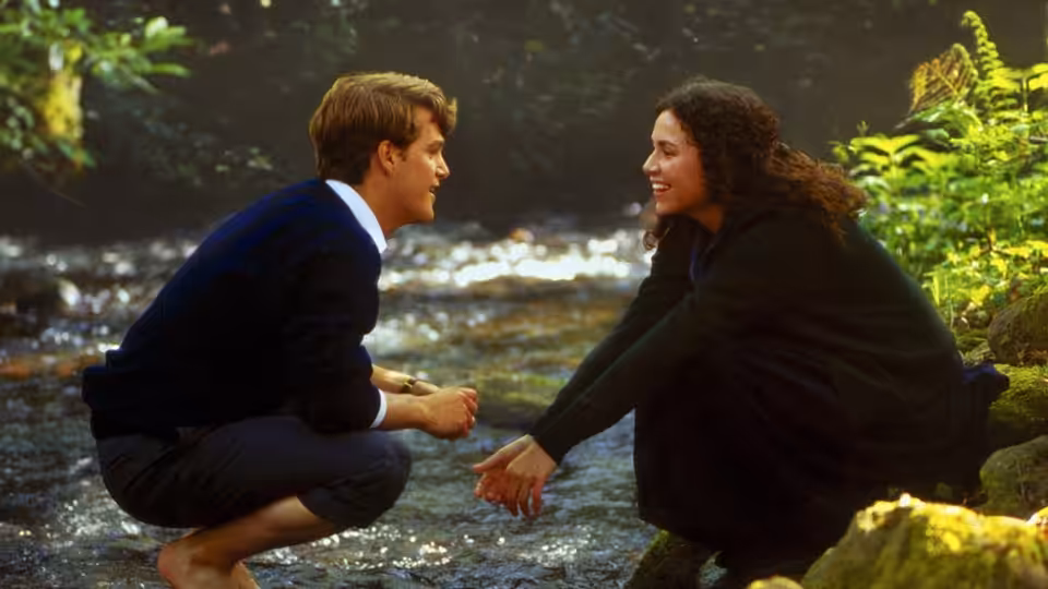 Jack Foley (Chris O'Donnell) and Benny Hogan (Minnie Driver) crouch beside a woodland stream