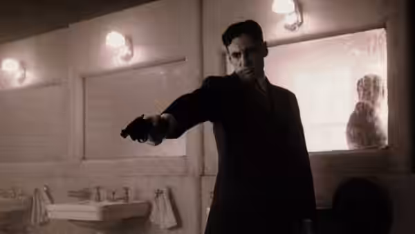 A man points a gun across a tiled institutional bathroom