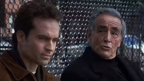 Michael (Brad Pitt) talks with Father Bobby (Robert De Niro) beside a chain-link fence