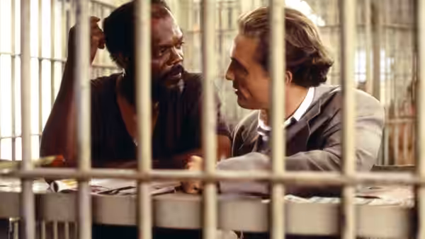 Jake Brigance (Matthew McConaughey) speaks with Carl Lee Hailey (Samuel L. Jackson) behind jail bars