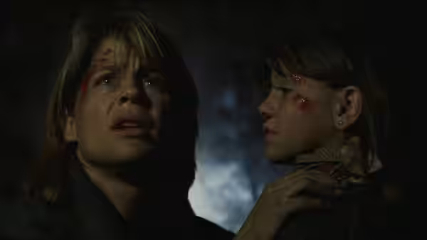 Rachel holds an injured girl close as they look into the darkness