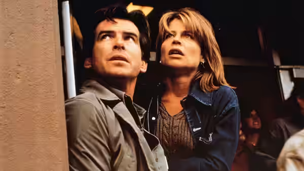 Harry Dalton (Pierce Brosnan) and Rachel Wando (Linda Hamilton) look upward from a doorway