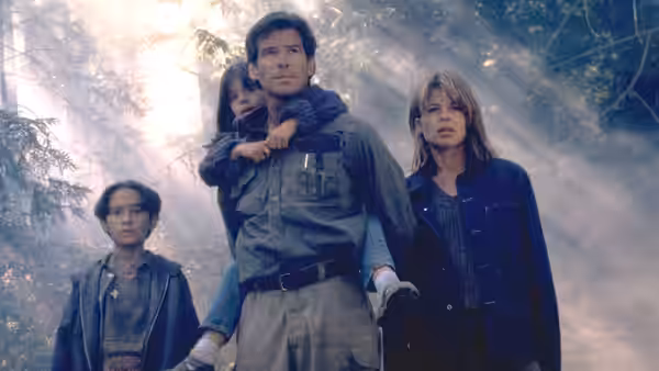 Harry Dalton (Pierce Brosnan), Rachel Wando (Linda Hamilton), and the children move through smoky woods