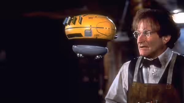 Professor Philip Brainard (Robin Williams) watches a hovering yellow robot in his laboratory