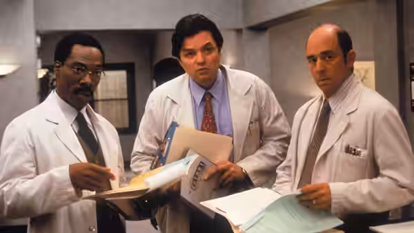 Dr. John Dolittle (Eddie Murphy) and two colleagues review paperwork in a hospital