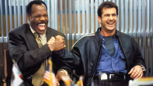 Roger Murtaugh (Danny Glover) and Martin Riggs (Mel Gibson) laugh together in a police station