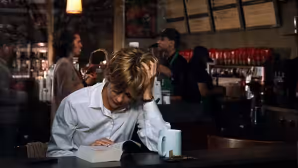 Kathleen Kelly (Meg Ryan) writes in a notebook at a café counter