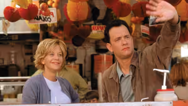 Kathleen Kelly (Meg Ryan) stands beside Joe Fox (Tom Hanks) at an outdoor market