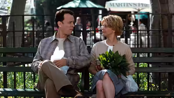Joe Fox (Tom Hanks) and Kathleen Kelly (Meg Ryan) sit together on a park bench