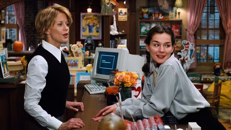 Kathleen Kelly (Meg Ryan) and a coworker behind the counter of a children's bookstore