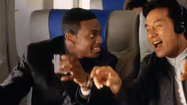 Carter (Chris Tucker) and Lee (Jackie Chan) laugh together aboard an airplane