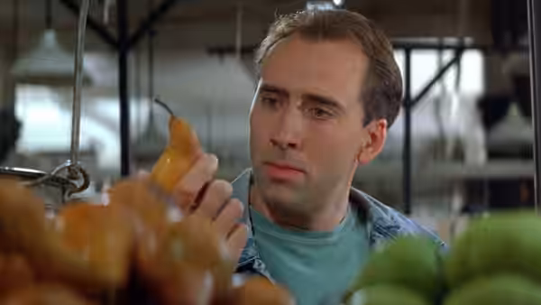 Seth (Nicolas Cage) examines a pear in a market produce stall