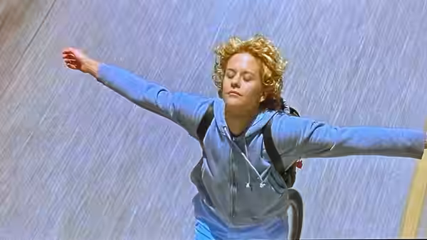 Maggie (Meg Ryan) stands with arms outstretched in the rain
