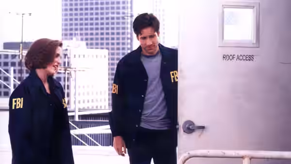 Dana Scully (Gillian Anderson) and Fox Mulder (David Duchovny) stand beside a rooftop access door