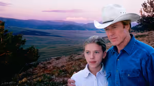 Tom Booker (Robert Redford) stands with Grace MacLean (Scarlett Johansson) overlooking a mountain valley