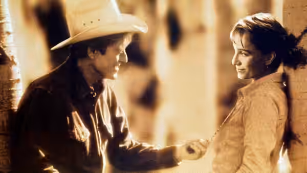 Tom Booker (Robert Redford) reaches toward Annie MacLean (Kristin Scott Thomas) indoors