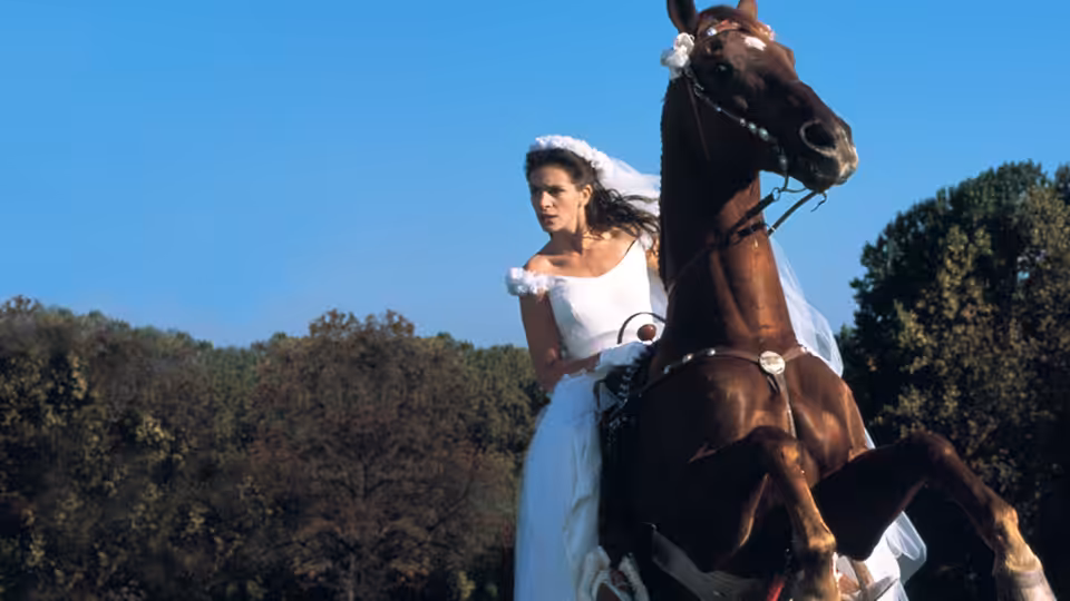 Maggie Carpenter (Julia Roberts) rides a rearing horse in her wedding dress outdoors