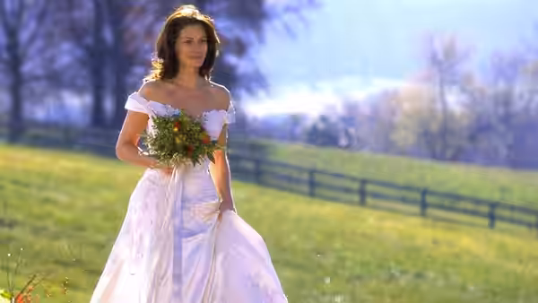 Maggie Carpenter (Julia Roberts) walks through a field in her wedding dress, carrying flowers