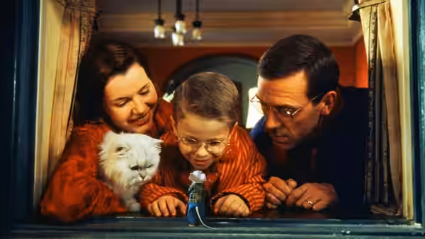 The Little family and Snowbell lean toward Stuart at a window