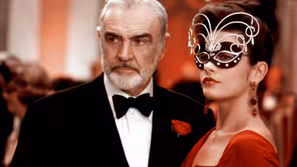 Mac (Sean Connery) stands beside masked Gin Baker (Catherine Zeta-Jones) at a formal event