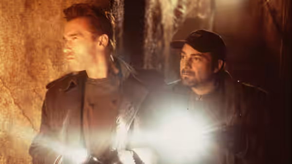 Jericho Cane (Arnold Schwarzenegger) and Bobby Chicago (Kevin Pollak) search with flashlights