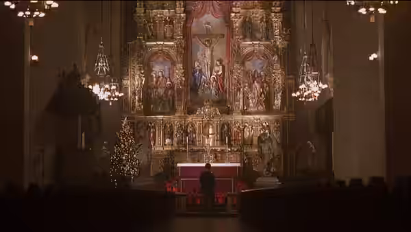 A lone figure stands before an ornate church altar