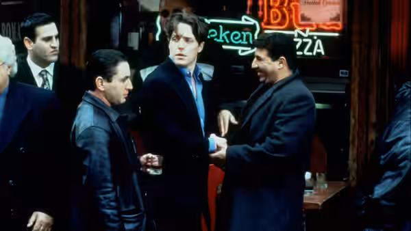 Michael Felgate (Hugh Grant) talks with Frank Vitale (James Caan) and other men outside a bar