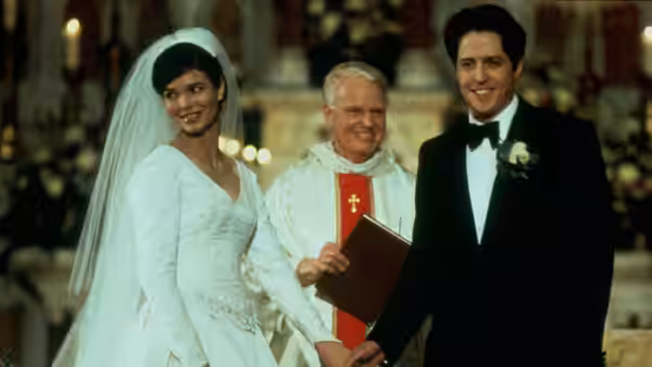 Gina Vitale (Jeanne Tripplehorn) and Michael Felgate (Hugh Grant) exchange wedding vows beside a priest