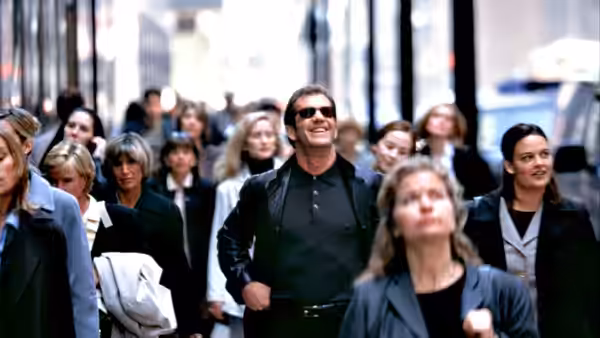 Nick Marshall (Mel Gibson) walks through an office corridor among women