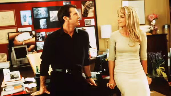 Nick Marshall (Mel Gibson) talks with Darcy McGuire (Helen Hunt) in an office
