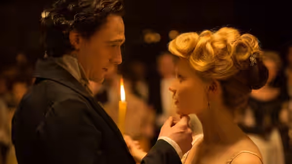 Sir Thomas Sharpe touches Edith Cushing’s chin at a candlelit gathering