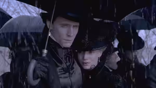 Sir Thomas Sharpe and Edith Cushing huddle beneath umbrellas in the rain