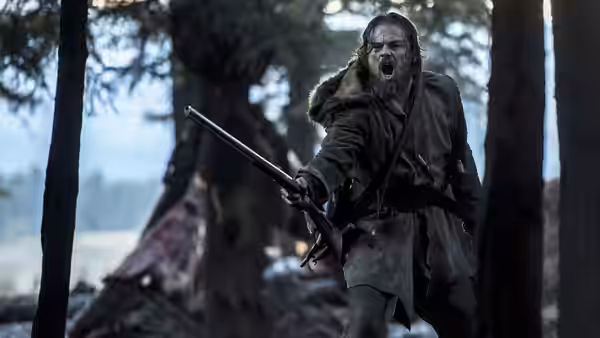 Hugh Glass (Leonardo DiCaprio) yelling with rifle in misty forest