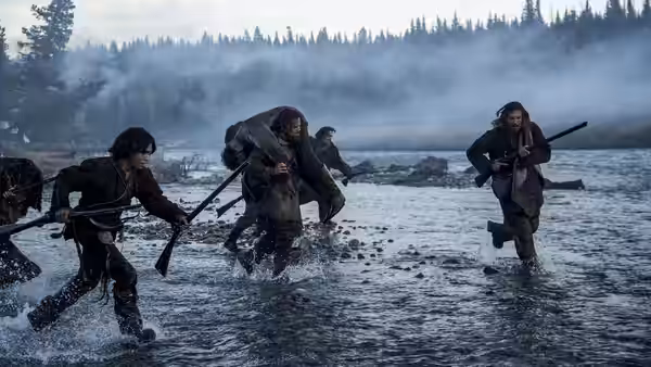 Group of men wading through a shallow river carrying rifles