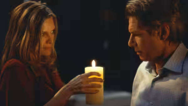 Claire Spencer (Michelle Pfeiffer) holds a lit candle beside Norman Spencer (Harrison Ford)